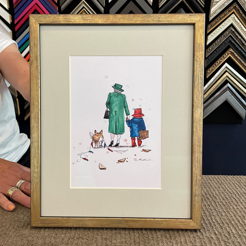 A framed image of Paddington bear and the queen