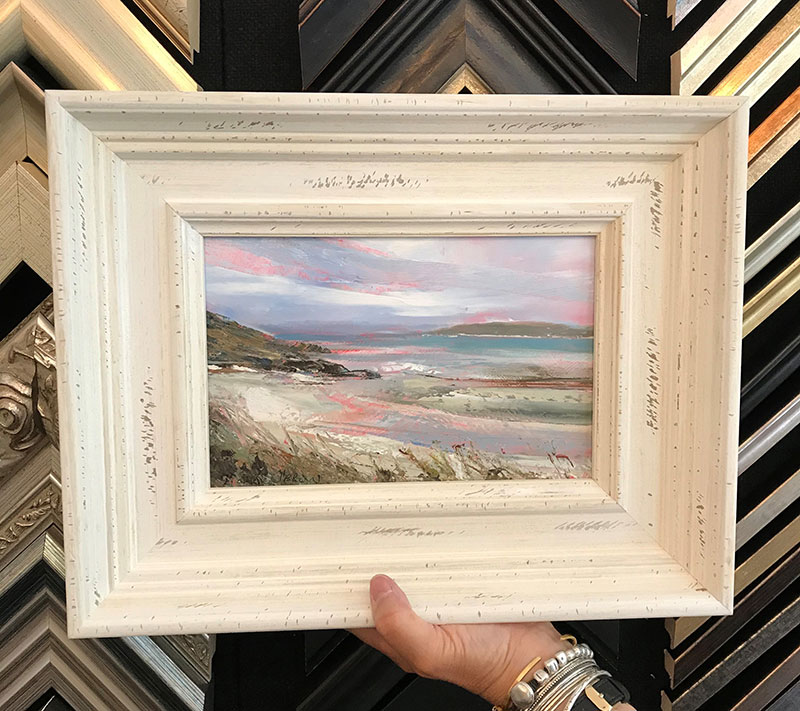 A seascape painting in a white frame