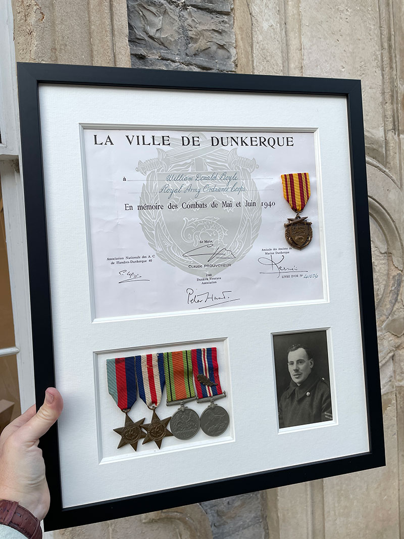 WWII memorabilia in a white display with a black frame