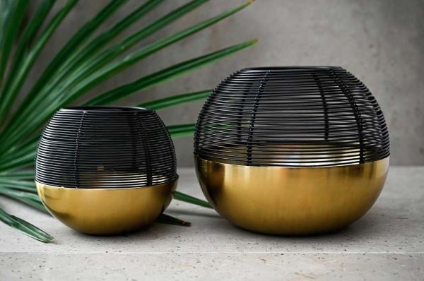 two candle holders with a solid base and cage top
