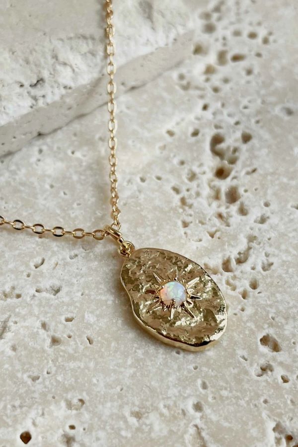 Gold coloured necklace pendant with a stone in the centre