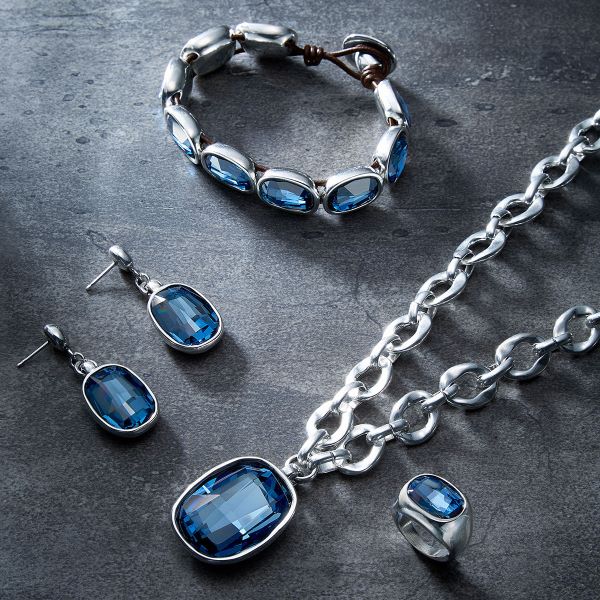 Silver jewellery set with a blue gem detail made up of a ring necklace, earrings and a bracelet