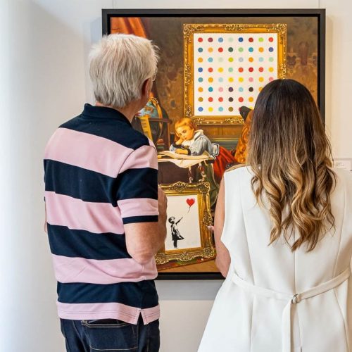 2 people viewing a painting at the pop of colour exhibition