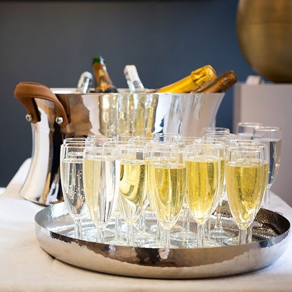 Glasses of Fizz laid out in front of an ice bucket of champagne at one of our events